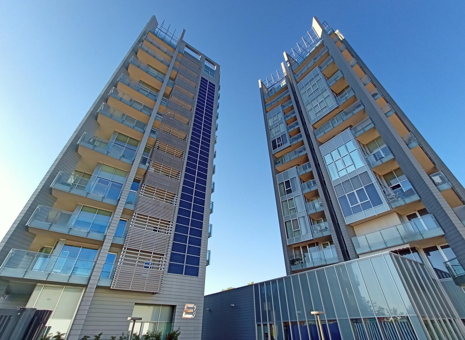supercondomini TAT, due grattacieli grigio-azzurri con pannelli solari
